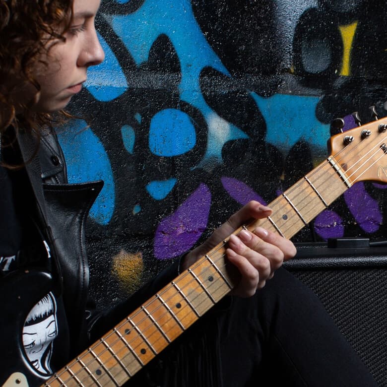 Guitarist playing electric guitar connected to a Marshall Code amplifier